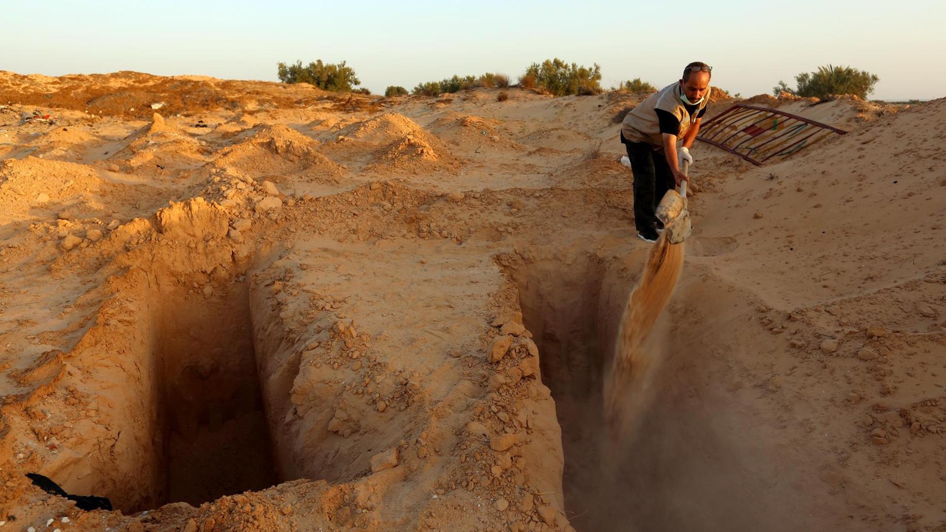 Der ehemalige Fischer Chamseddine Marzoug gräbt ein Grab für einen weiteren Migranten auf dem behelfsmäßigen "Friedhof der Unbekannten" in Zarzis/ Tunesien