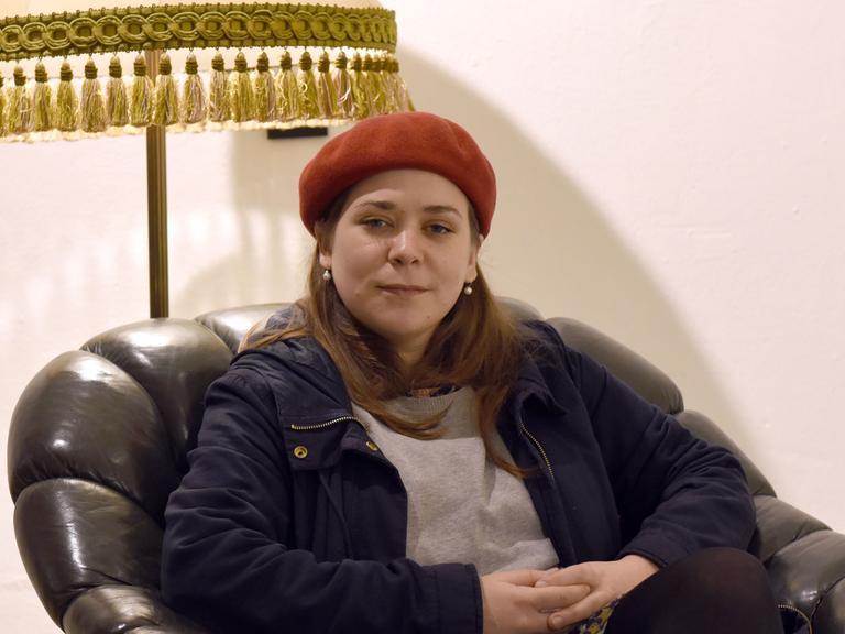 Die österreichische Bloggerin und Autorin Stefanie Sargnagel sitzt in einem braunen Ledersessel