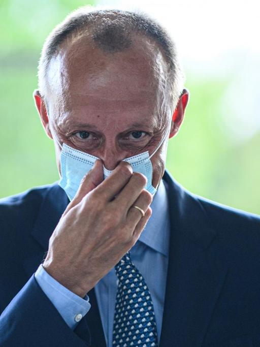 Der CDU Politiker Friedrich Merz richtet seine Coronamaske, 2020.