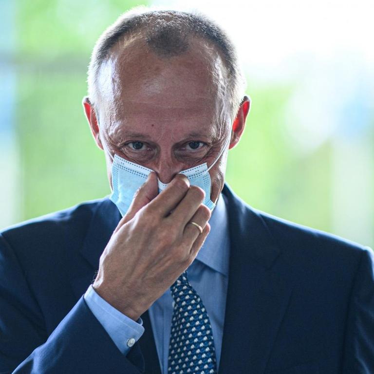 Der CDU Politiker Friedrich Merz richtet seine Coronamaske, 2020.