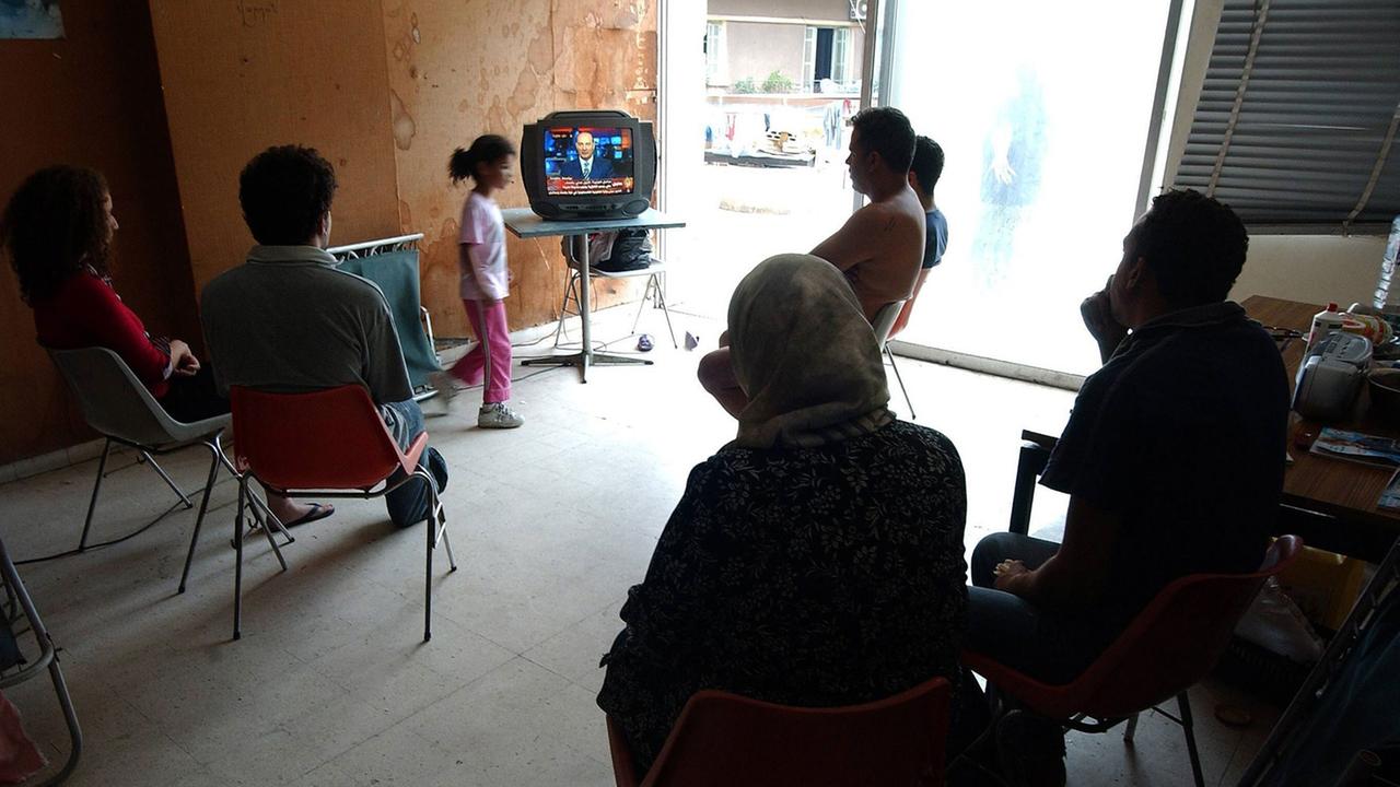 Libanesische Flüchtlinge sehen Fernsehen in ihrer Notunterkunft in Beirut Libanesische Flüchtlinge sehen Fernsehen in ihrer Notunterkunft in Beirut