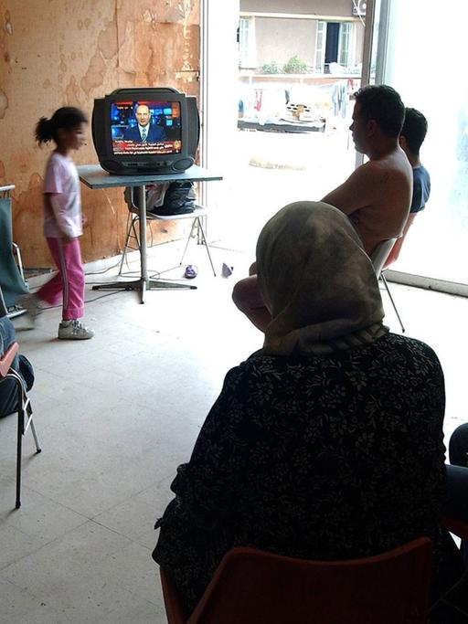 Libanesische Flüchtlinge sehen Fernsehen in ihrer Notunterkunft in Beirut