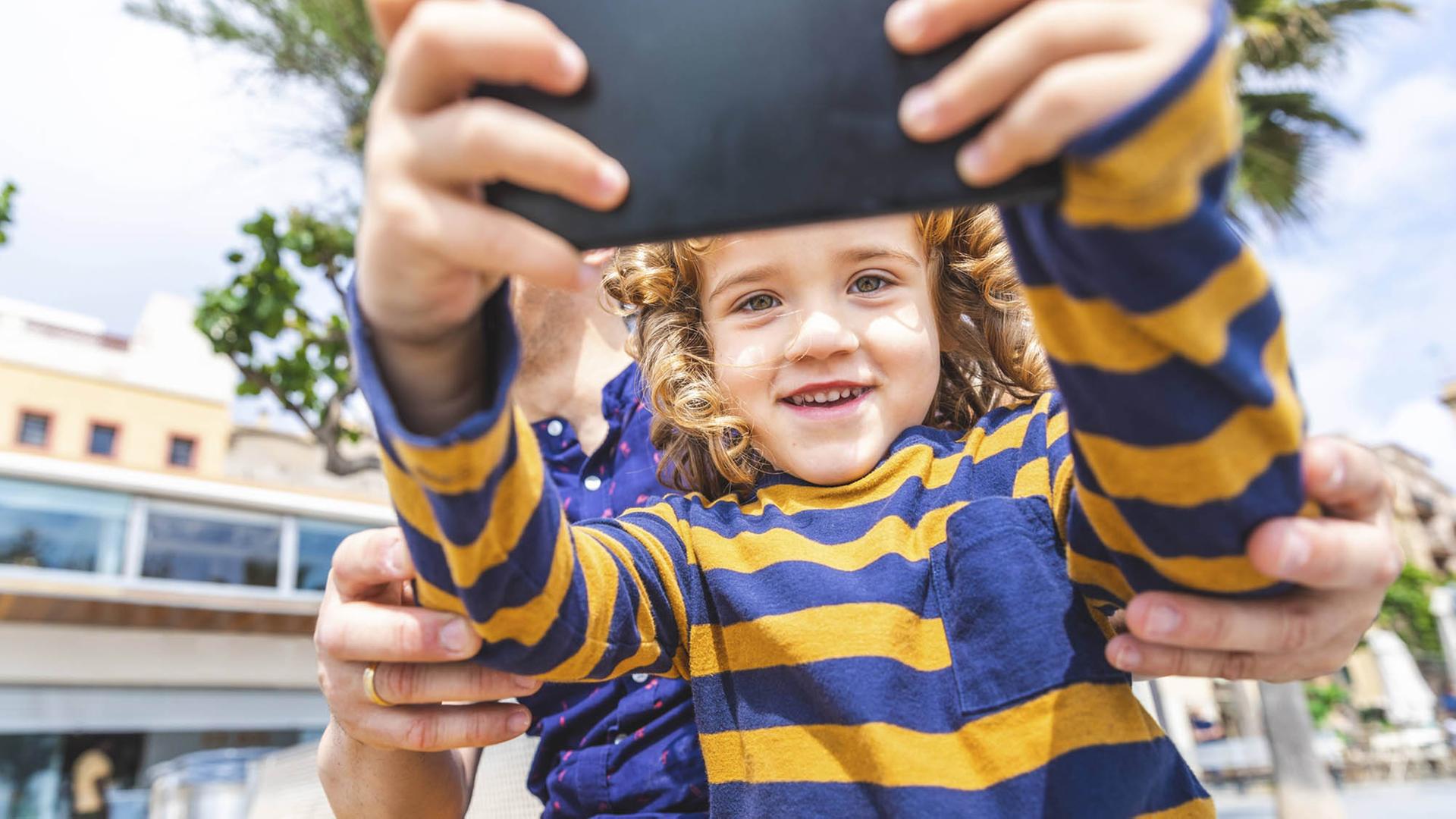 Ein Kind macht ein Selfie von sich und seinem Vater. Ein Kind macht ein Selfie von sich und seinem Vater.
