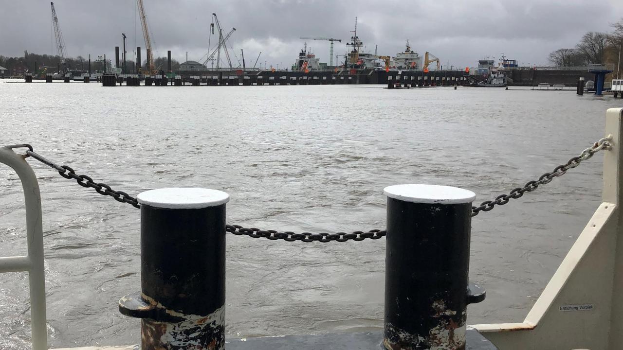 Im Vordergrund ist die Bordwand der Kanalfähre auf dem Nord-Ostsee-Kanal zu sehen. Im Hintergrund die Schleusen von Brunsbüttel. Im Vordergrund ist die Bordwand der Kanalfähre auf dem Nord-Ostsee-Kanal zu sehen. Im Hintergrund die Schleusen von Brunsbüttel.