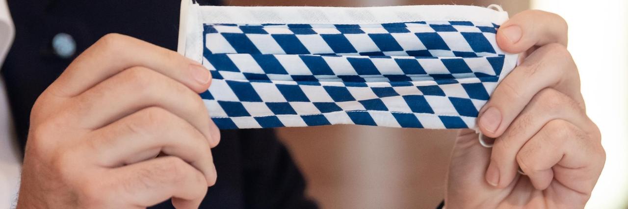 Markus Söder (CSU), Ministerpräsident von Bayern, nimmt an einer Sitzung des bayerischen Kabinetts teil und hält dabei einen Mundschutz mit der bayerischen Rautenflagge in den Händen. Markus Söder (CSU), Ministerpräsident von Bayern, nimmt an einer Sitzung des bayerischen Kabinetts teil und hält dabei einen Mundschutz mit der bayerischen Rautenflagge in den Händen.