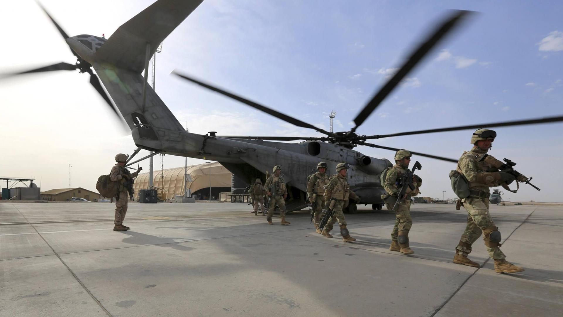US-Marines bei einem Einsatz im Nahen Osten: Ein Hubschrauber landet gerade, mehrere Soldaten befinden sich auf dem Flugplatz.