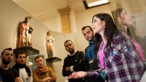 Die aus Damaskus stammende Syrerin Rita Albahri führt am 16.12.2015 in Berlin im Deutschen Historischen Museum einen Klasse eines Deutschkurses für Flüchtlinge durch die Ausstellung "Deutsche Geschichte in Bildern und Zeugnissen.