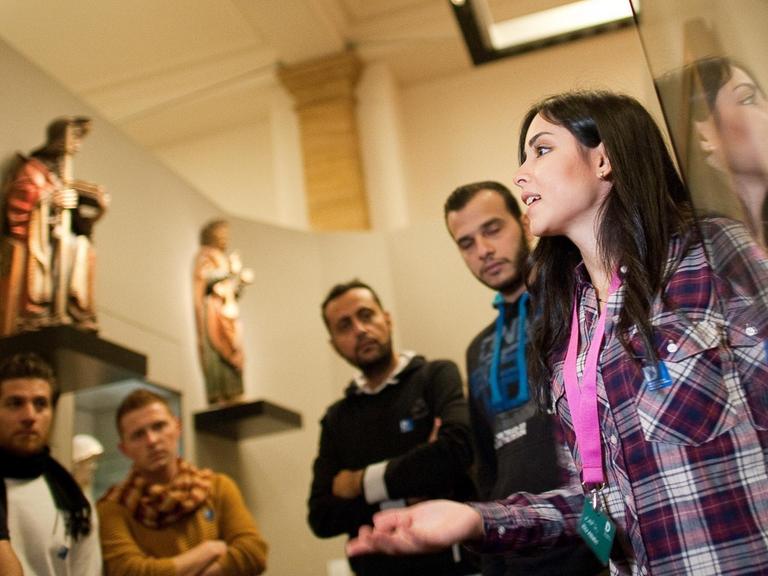 Die aus Damaskus stammende Syrerin Rita Albahri führt am 16.12.2015 in Berlin im Deutschen Historischen Museum einen Klasse eines Deutschkurses für Flüchtlinge durch die Ausstellung "Deutsche Geschichte in Bildern und Zeugnissen.