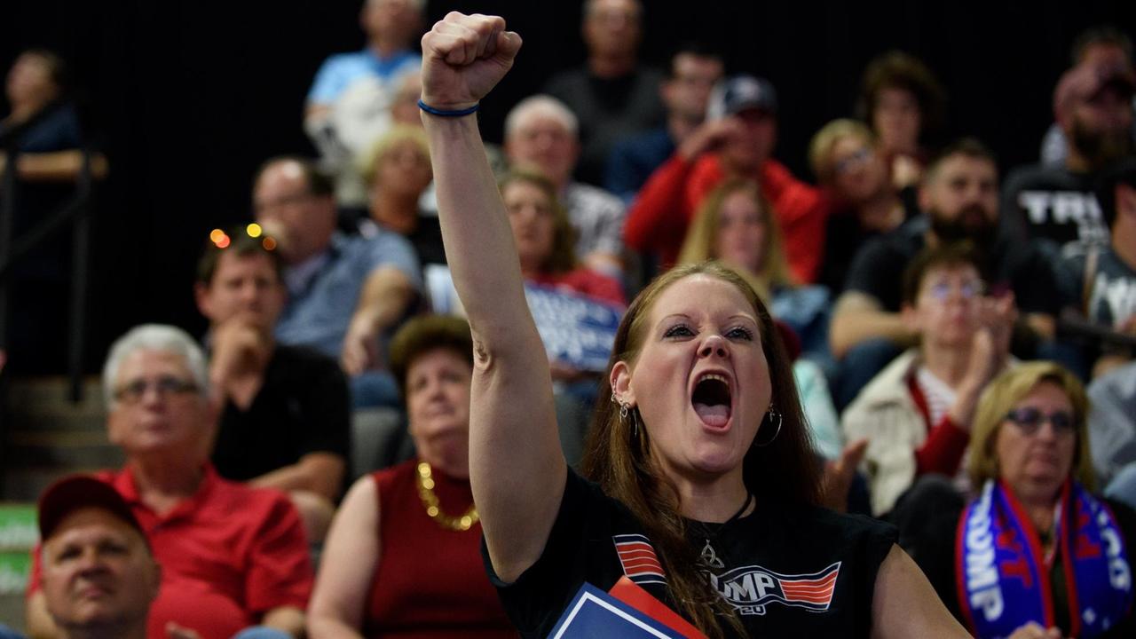 Eine junge Anhängerin von Trump schreit begeistert und streckt ihre Faust in die Luft, als Trump eine "Make America Great Again" Rede in West Virginia hält. Eine junge Anhängerin von Trump schreit begeistert und streckt ihre Faust in die Luft, als Trump eine "Make America Great Again" Rede in West Virginia hält.