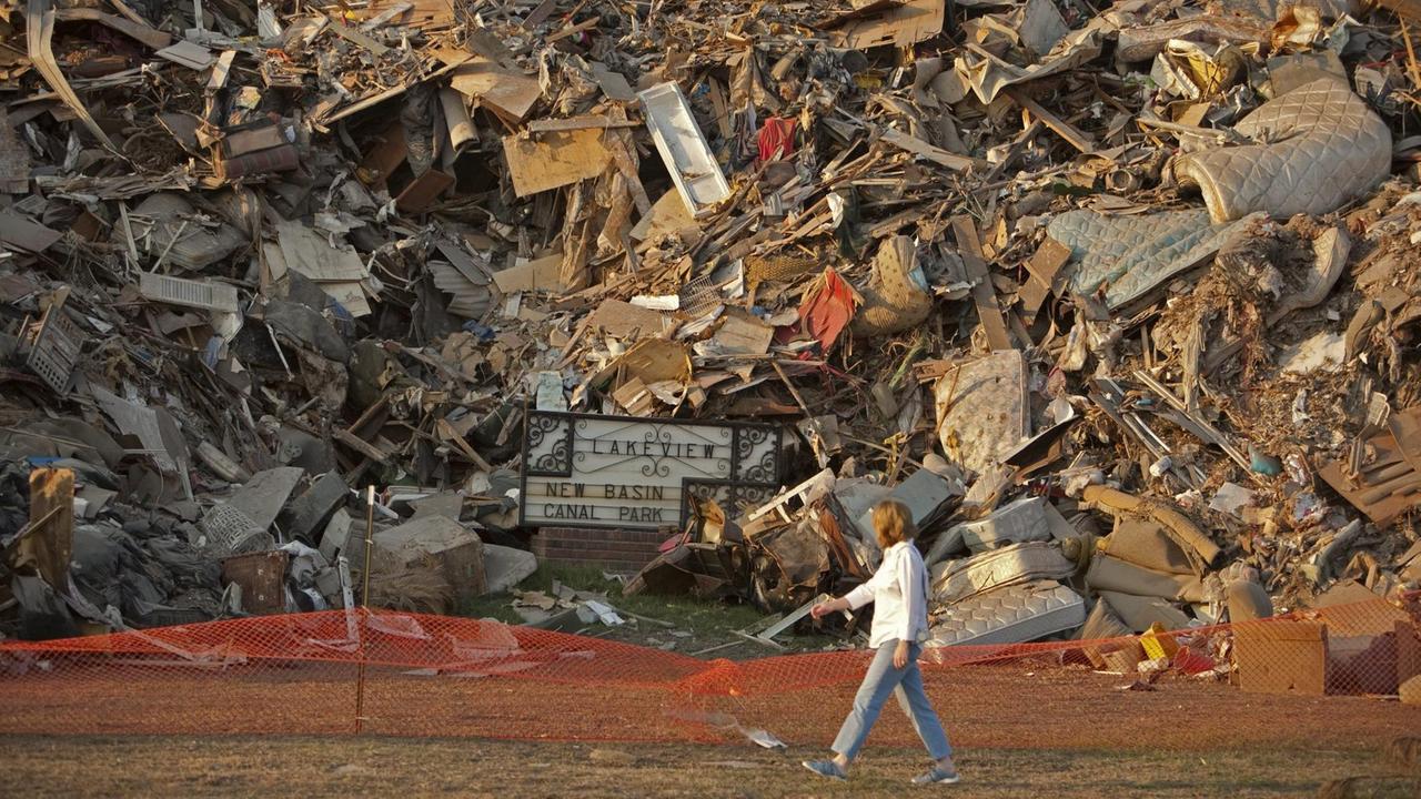 Eine Frau geht vor einer Wand aus Geröll und Schrott - aufgetürmt durch die Flutwelle, die der Hurrikan Katrina am 29. August 2005 durch New Orleans schob. (Aufnahme vom 21. Oktober 2005) Eine Frau geht vor einer Wand aus Geröll und Schrott - aufgetürmt durch die Flutwelle, die der Hurrikan Katrina am 29. August 2005 durch New Orleans schob. (Aufnahme vom 21. Oktober 2005)