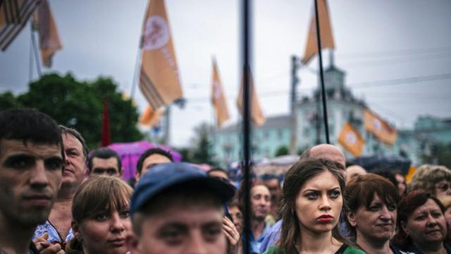 Ukrainer verfolgen in der Stadt Lugansk eine Feier pro-russischer Separatisten nach dem Ausgang der Unabhängigskeitswahlen im Osten des Landes.