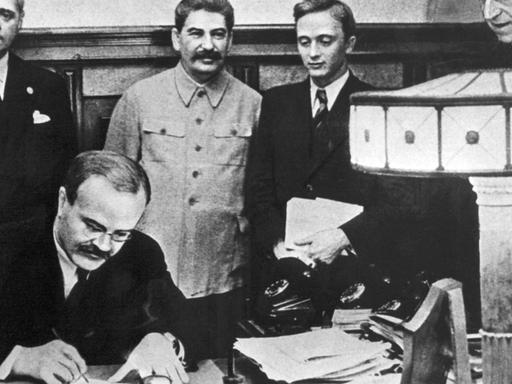 Am 23. August 1939 unterzeichneten der Außenminister des Deutschen Reiches, Joachim von Ribbentrop (l) und der sowjetische Außenminister Wjatscheslaw Molotow (vorn) in Moskau den deutsch-russischen Nichtangriffspakt. Hinten neben Ribbentrop Josef Stalin, ganz rechts Friedrich Gaus, daneben U. Pavlov.