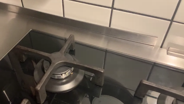 Blick auf eine Edelstahl-Küchenarbeitsplatte und den Fliesenspiegel.