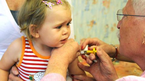 Der Kinder-und Jugendarzt Dr. Klaus Schwieger impft in seiner Praxis in Leipzig ein 21 Monate altes Kleinkind
