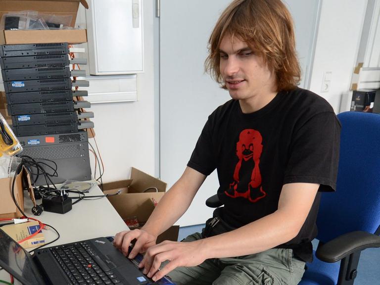 Ein blinder Student liest mit Hilfe einer Braillezeile am Computer.