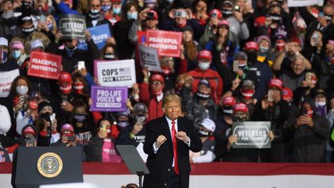 Präsident Trump bei einer Wahlkampfveranstaltung in Johnstown, Pennsylvania. Im Hintergrund Anhängerinnen mit Bannern.