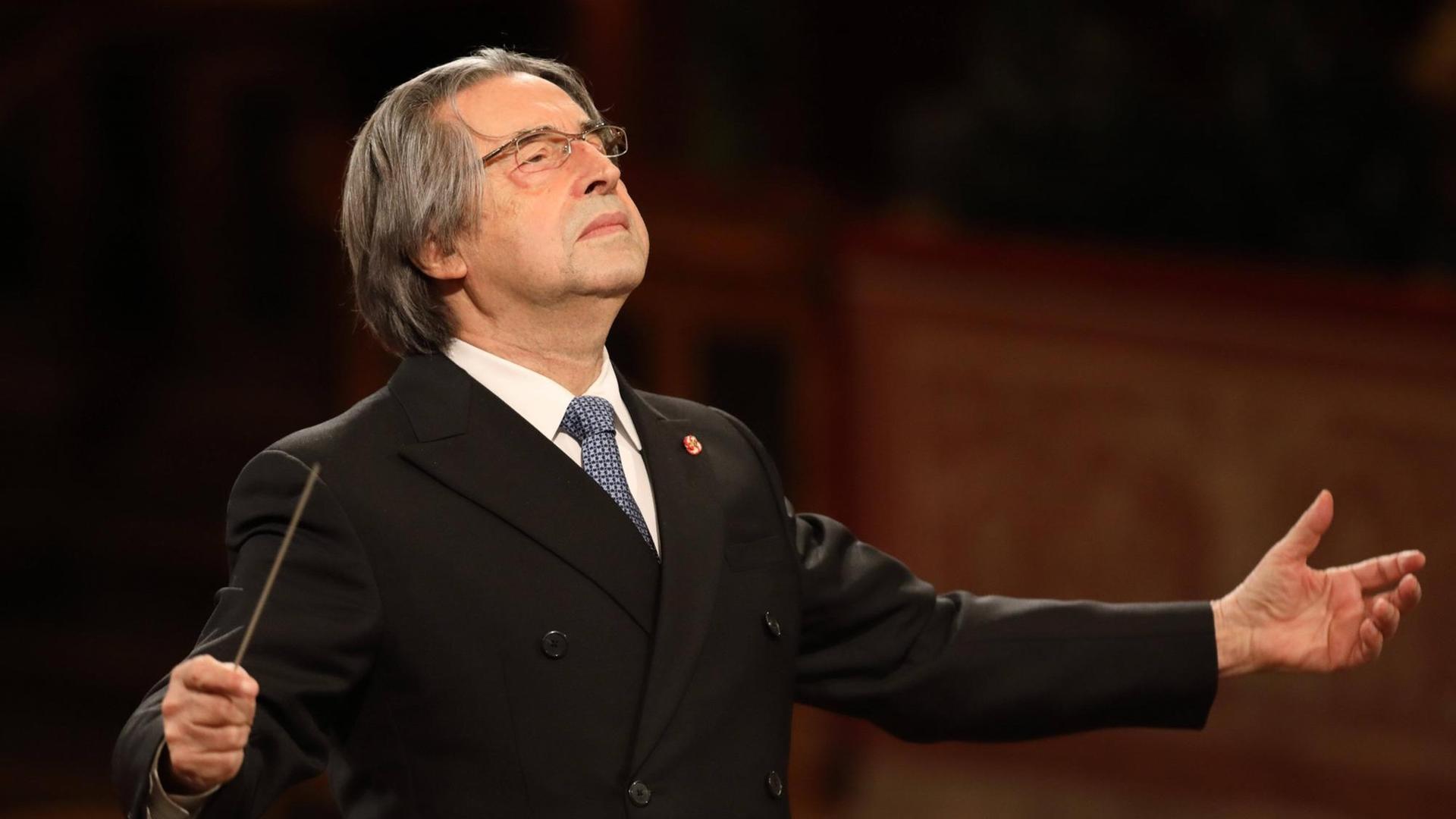 Dirigent Riccardo Muti steht mit geöffneten Armen und leicht in den Nacken gelegtem Kopf am Dirigentenpult der Wiener Philharmoniker im Jahr 2021. Dirigent Riccardo Muti steht mit geöffneten Armen und leicht in den Nacken gelegtem Kopf am Dirigentenpult der Wiener Philharmoniker im Jahr 2021.