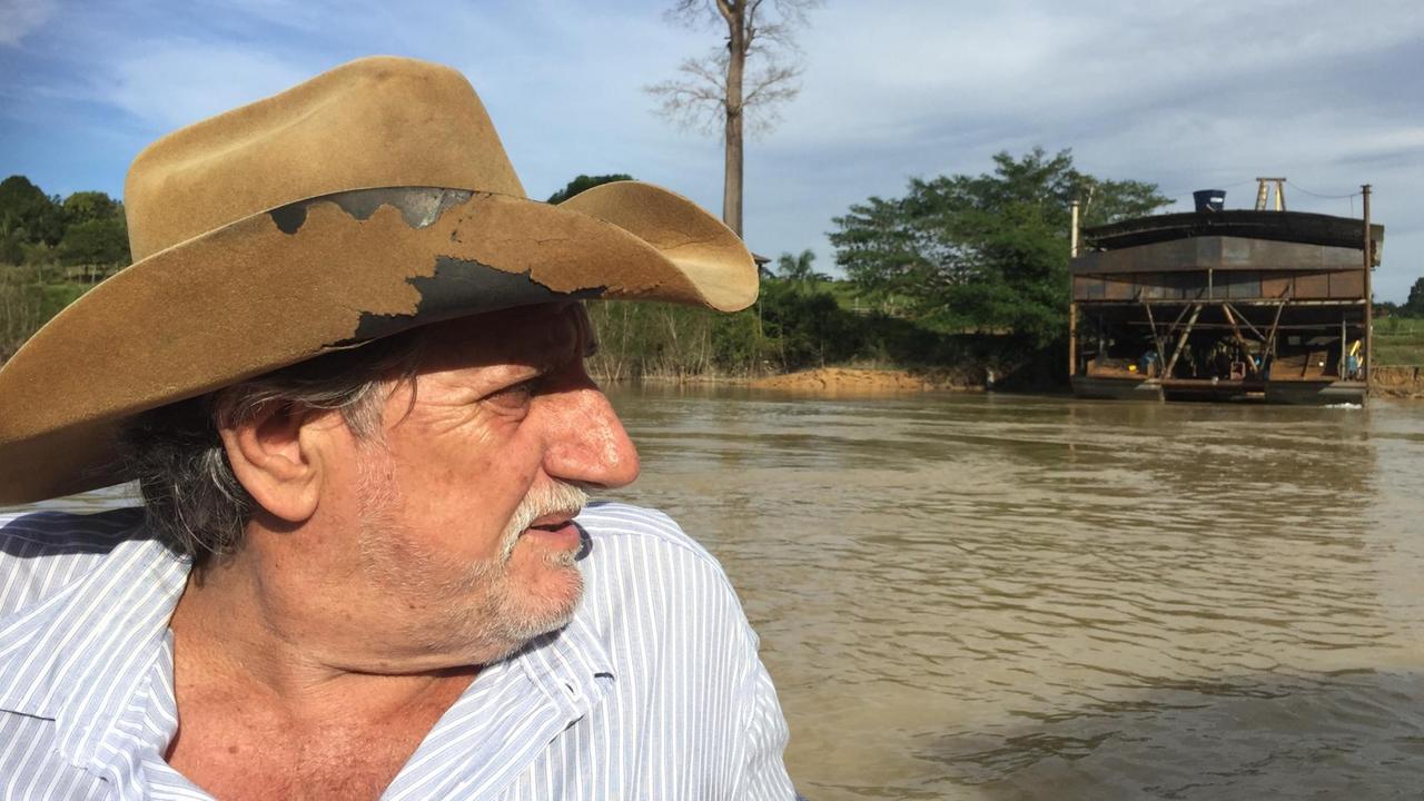 Der Goldschürfer sitzt mit Schlapphut im Boot und schaut über die Schulter. Der Goldschürfer sitzt mit Schlapphut im Boot und schaut über die Schulter.