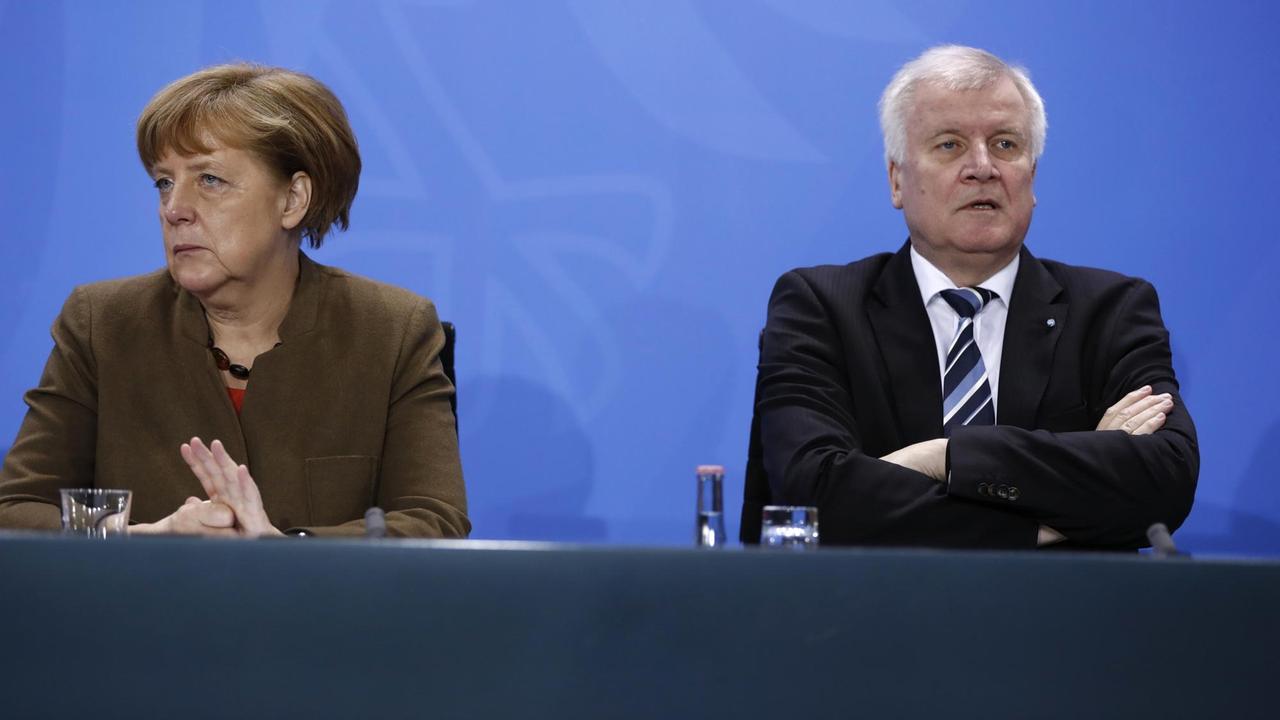 Bundeskanzlerin Angela Merkel und CSU-Chef Horst Seehofer sitzen voneinander abgewendet nebeneinander bei einer Pressekonferenz. Bundeskanzlerin Angela Merkel und CSU-Chef Horst Seehofer sitzen voneinander abgewendet nebeneinander bei einer Pressekonferenz.