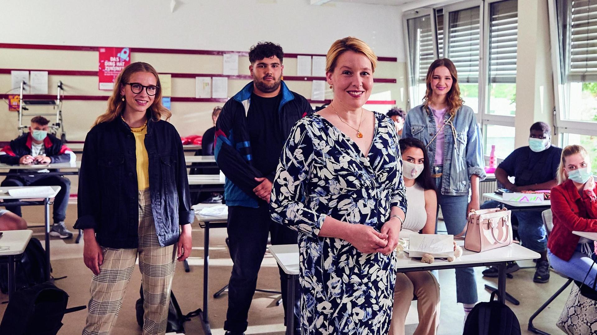 In einem Klassenzimmer stehen die drei Hauptdarsteller der Miniserie "Ehrenpflegas" und Bundesfamilienministerin Franziska Giffey. In einem Klassenzimmer stehen die drei Hauptdarsteller der Miniserie "Ehrenpflegas" und Bundesfamilienministerin Franziska Giffey.