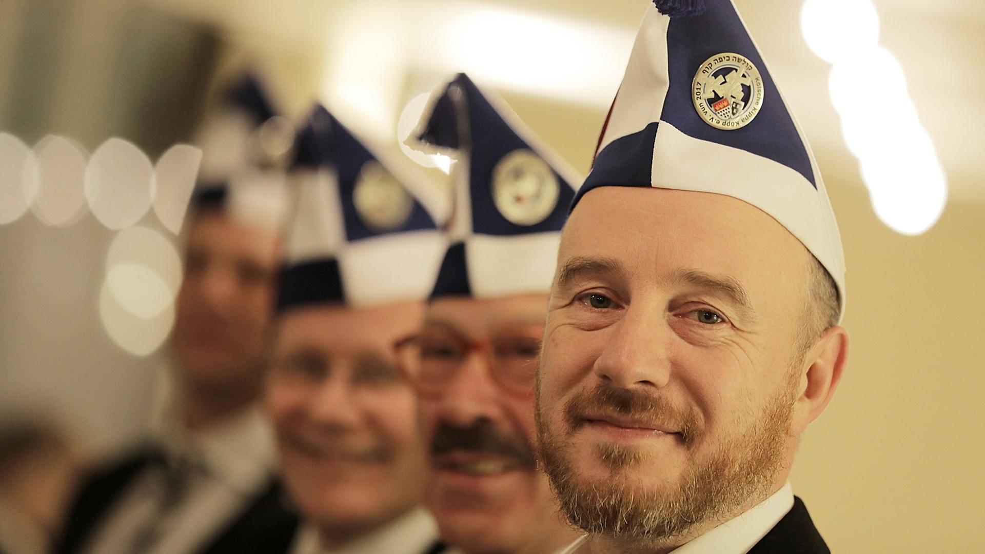 Aaron Knappstein (r), Präsident des jüdischen Karneval Vereins Kölsche Kippa Köpp e.V., steht vor dem Besuch einer Sitzung mit Mitgliedern im Foyer in einer Halle. Aaron Knappstein (r), Präsident des jüdischen Karneval Vereins Kölsche Kippa Köpp e.V., steht vor dem Besuch einer Sitzung mit Mitgliedern im Foyer in einer Halle.