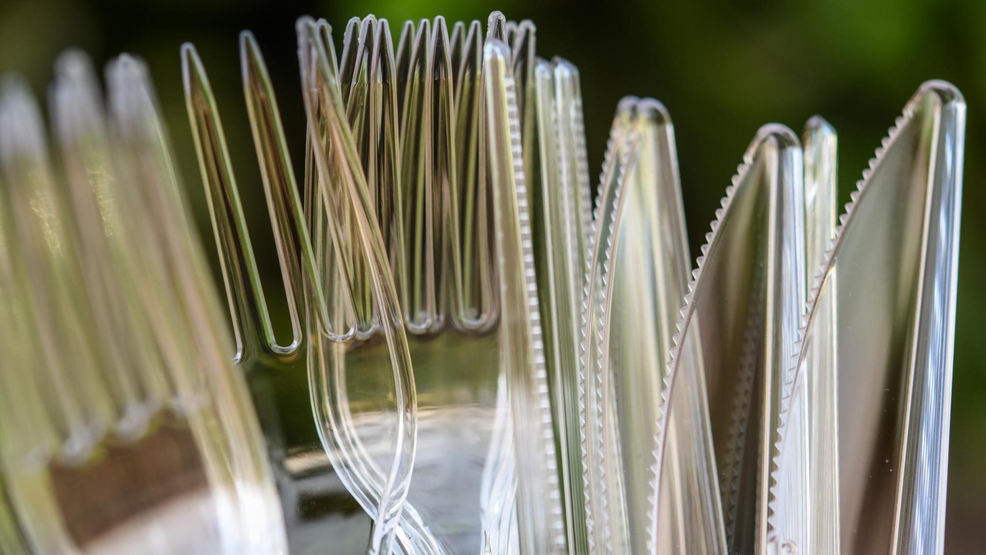 Messer und Gabeln aus Plastik stehen in einem Kunststoffbecher Messer und Gabeln aus Plastik stehen in einem Kunststoffbecher