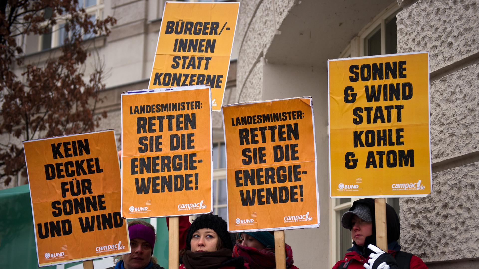 Menschen demonstrieren mit orangenen Plaktaten gegen die Ökostrom-Reformpläne von Sigmar Gabriel. Menschen demonstrieren mit orangenen Plaktaten gegen die Ökostrom-Reformpläne von Sigmar Gabriel.
