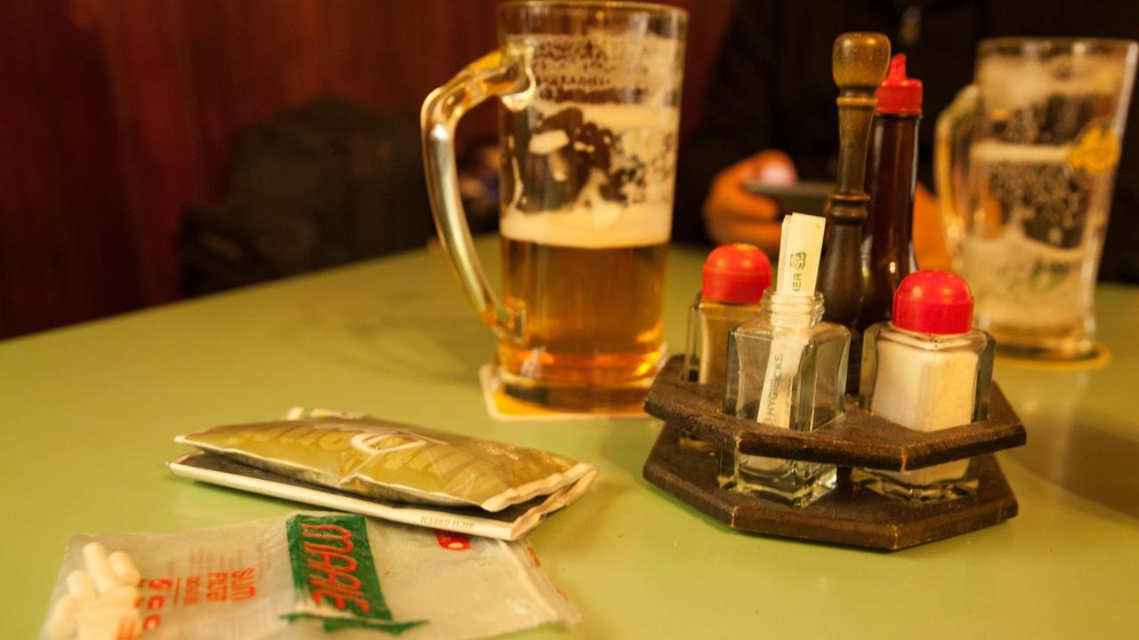 Detailaufnahme von Bierkrügen, Soßenwürze und Rauchutensilien in typischem Kneipenambiente. Detailaufnahme von Bierkrügen, Soßenwürze und Rauchutensilien in typischem Kneipenambiente.