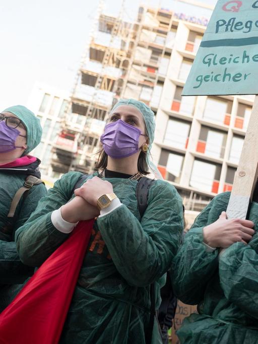 Pflegekräfte, die an einer einer Demonstration zum Internationalen Frauentag teilnehmen, halten Plakate. Seit genau 100 Jahren wird an jedem 8. März weltweit für Frauenrechte, für Gleichberechtigung und Emanzipation demonstriert.