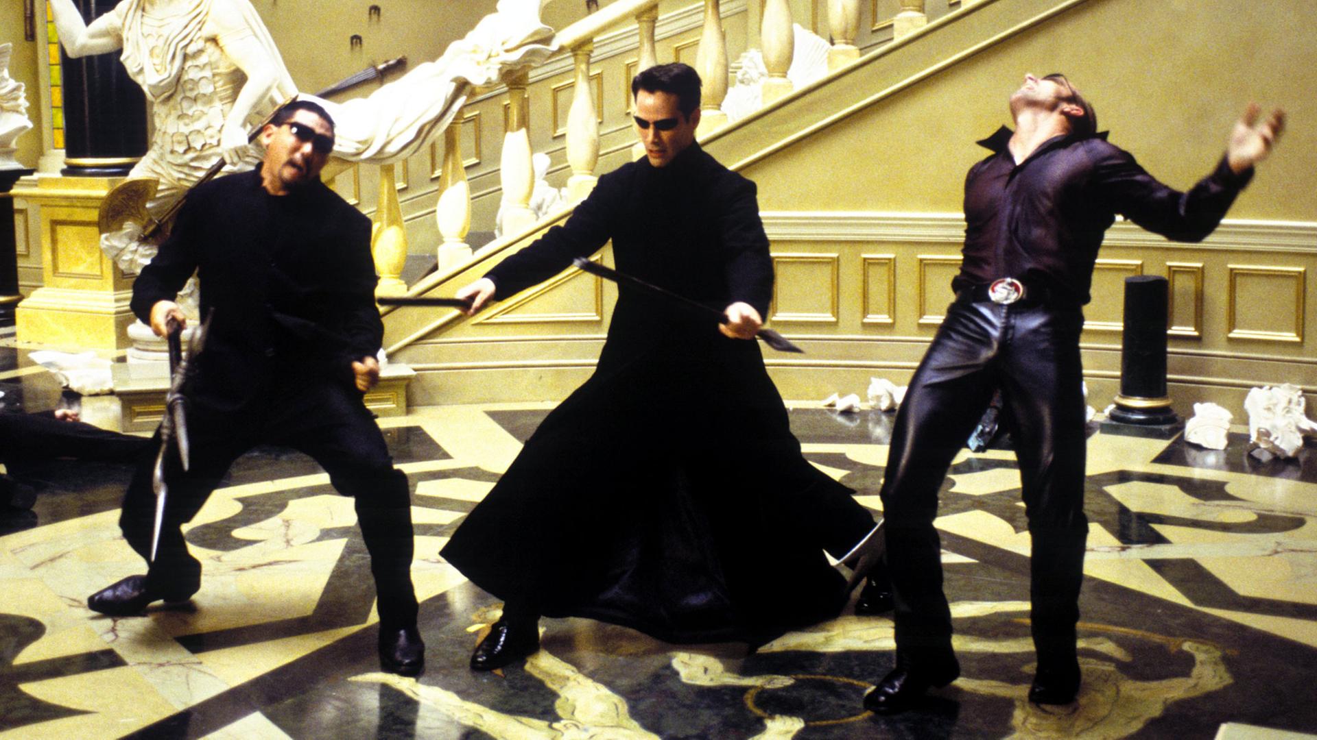 Thomas "Neo" Anderson (Keanu Reeves) streckt im neuen Kinofilm "Matrix - Reloaded" zwei Gegenspieler nieder (Szenenfoto). Thomas "Neo" Anderson (Keanu Reeves) streckt im neuen Kinofilm "Matrix - Reloaded" zwei Gegenspieler nieder (Szenenfoto).