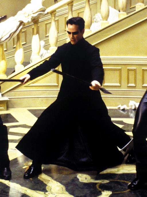 Thomas "Neo" Anderson (Keanu Reeves) streckt im neuen Kinofilm "Matrix - Reloaded" zwei Gegenspieler nieder (Szenenfoto).