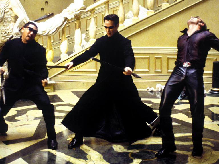 Thomas "Neo" Anderson (Keanu Reeves) streckt im neuen Kinofilm "Matrix - Reloaded" zwei Gegenspieler nieder (Szenenfoto).