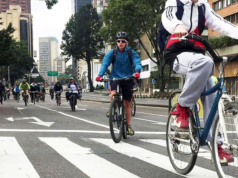 Fahrradfahrer und Fahrerinnen auf einer Fahrradstraße in Bogotá.