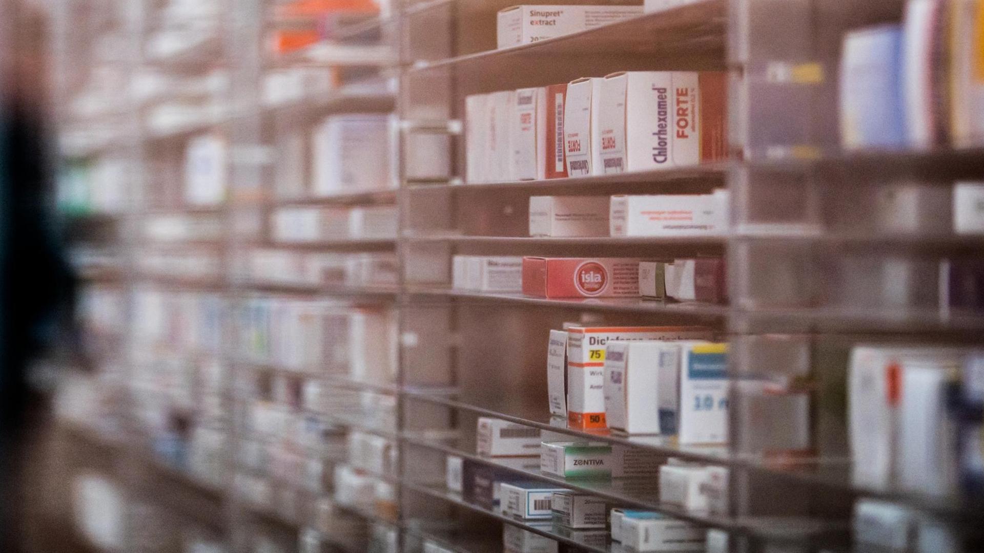 Blick durch eine Glasscheibe auf ein vollautomatisches Medikamenten-Lager, Symbolbild Lieferengpässe von Medikamenten