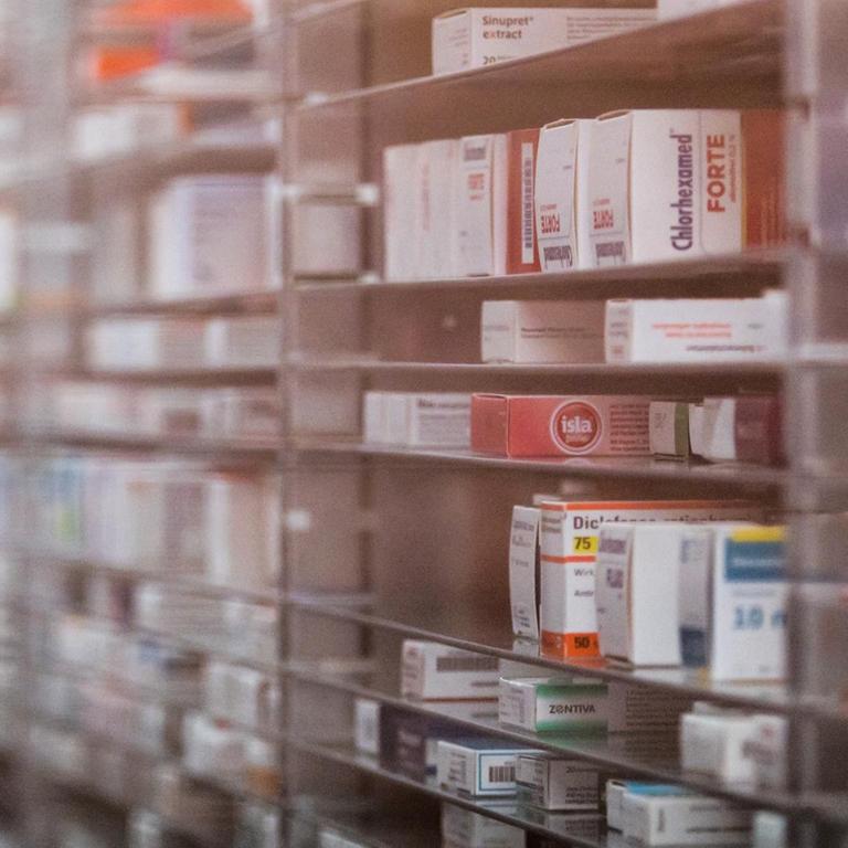 Blick durch eine Glasscheibe auf ein vollautomatisches Medikamenten-Lager, Symbolbild Lieferengpässe von Medikamenten