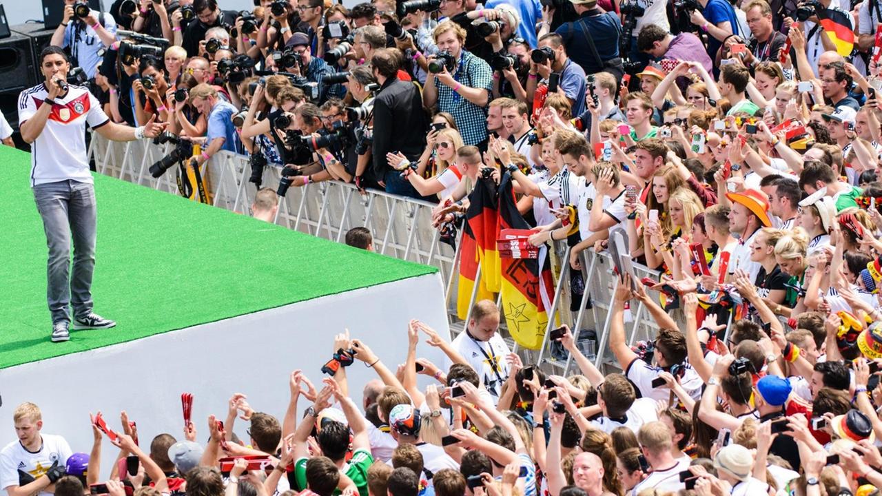 Sänger Andreas Bourani auf der Bühne, umringt von Fans, beim Empfang der deutschen Fussball Nationalmannschaft am Brandenburger Tor in Berlin.