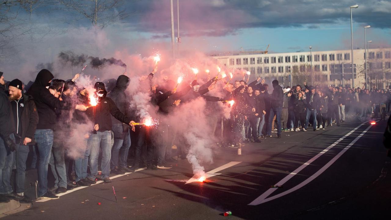 Die Gladbacher Fans empfangen den Gladbacher Mannschaftsbus vor dem Stadion und zünden dabei Pyrotechnik an.