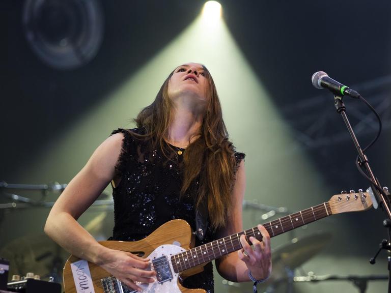 Die Musikerin Sophie Hunger steht bei einem Auftritt im Juli 2019 in einem Lichtkegel auf der Bühne und schaut nach oben.