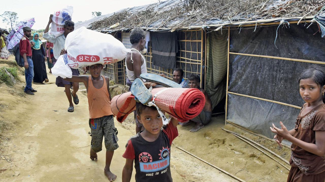 Geflüchtete Rohingya tragen in einem Camp in Cox's Bazaar im Südosten von Bangladesch verteilte Hilfsgüter. Geflüchtete Rohingya tragen in einem Camp in Cox's Bazaar im Südosten von Bangladesch verteilte Hilfsgüter.