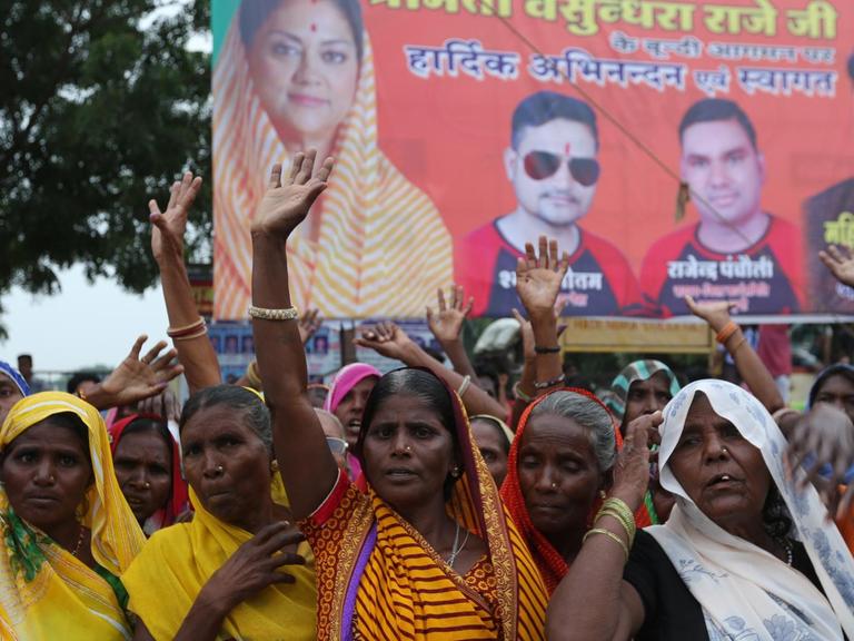 Frauen in indischer Kleidung mit erhobenen Händen demonstrieren für ihre Rechte.