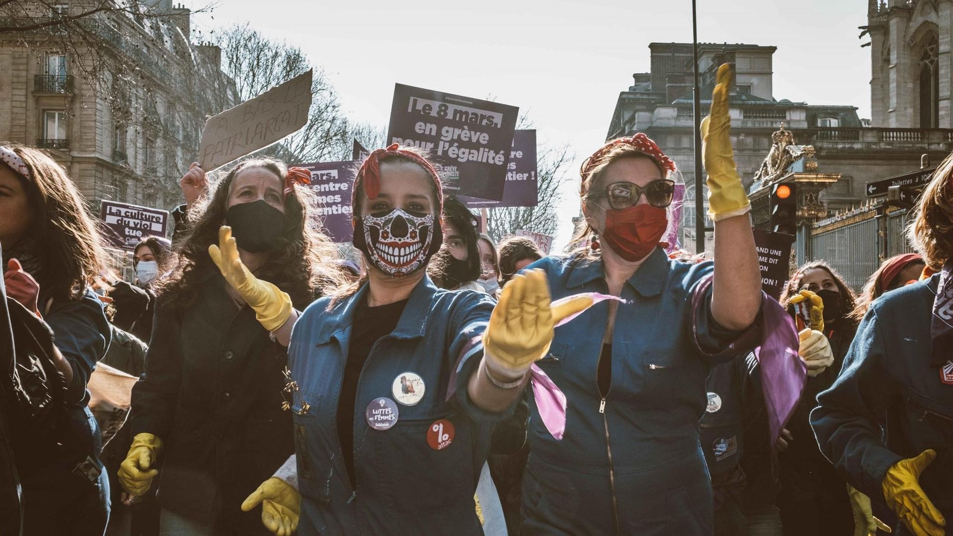 Eine Gruppe junger Frauen mit Mund-Nasenschutz demonstriert auf der Straße für Gleichstellung. Eine Gruppe junger Frauen mit Mund-Nasenschutz demonstriert auf der Straße für Gleichstellung.