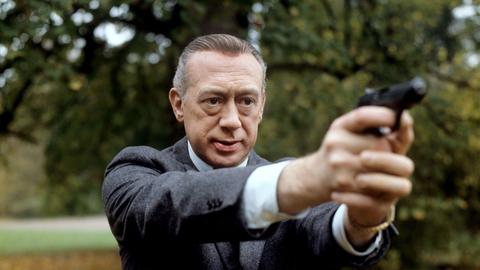 Der deutsche Schauspieler Horst Tappert als Kommissar Stefan Derrick in einer Filmszene mit seiner Pistole im Anschlag. Aufgenommen November 1977.