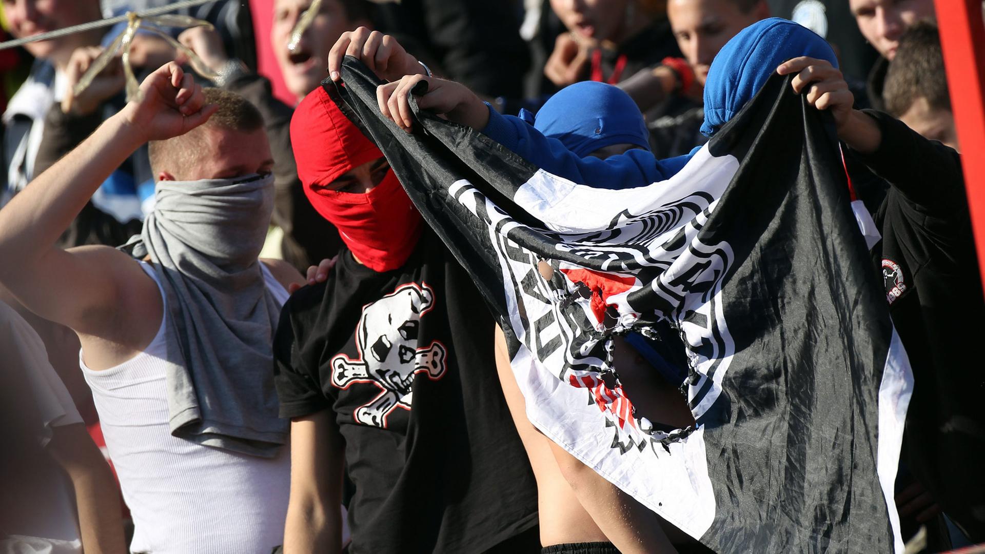 Fans von Roter Stern Belgrad halten beim Derby in der serbischen Liga am 23.10.2010 eine beschädigte Partizan-Belgrad-Fahne.
