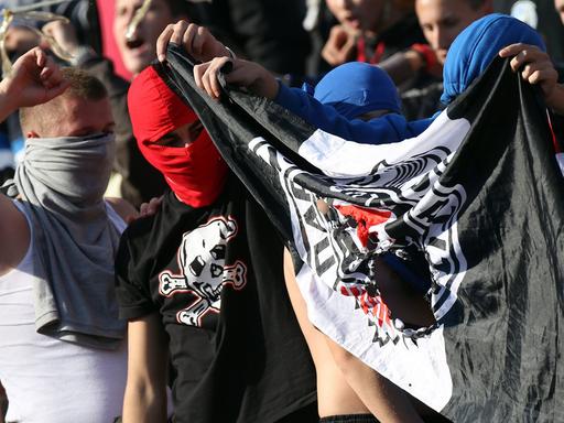 Fans von Roter Stern Belgrad halten beim Derby in der serbischen Liga am 23.10.2010 eine beschädigte Partizan-Belgrad-Fahne.