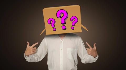 Ein Mann trägt eine Box auf dem Kopf, auf dem drei Fragezeichen aufgemalt sind.