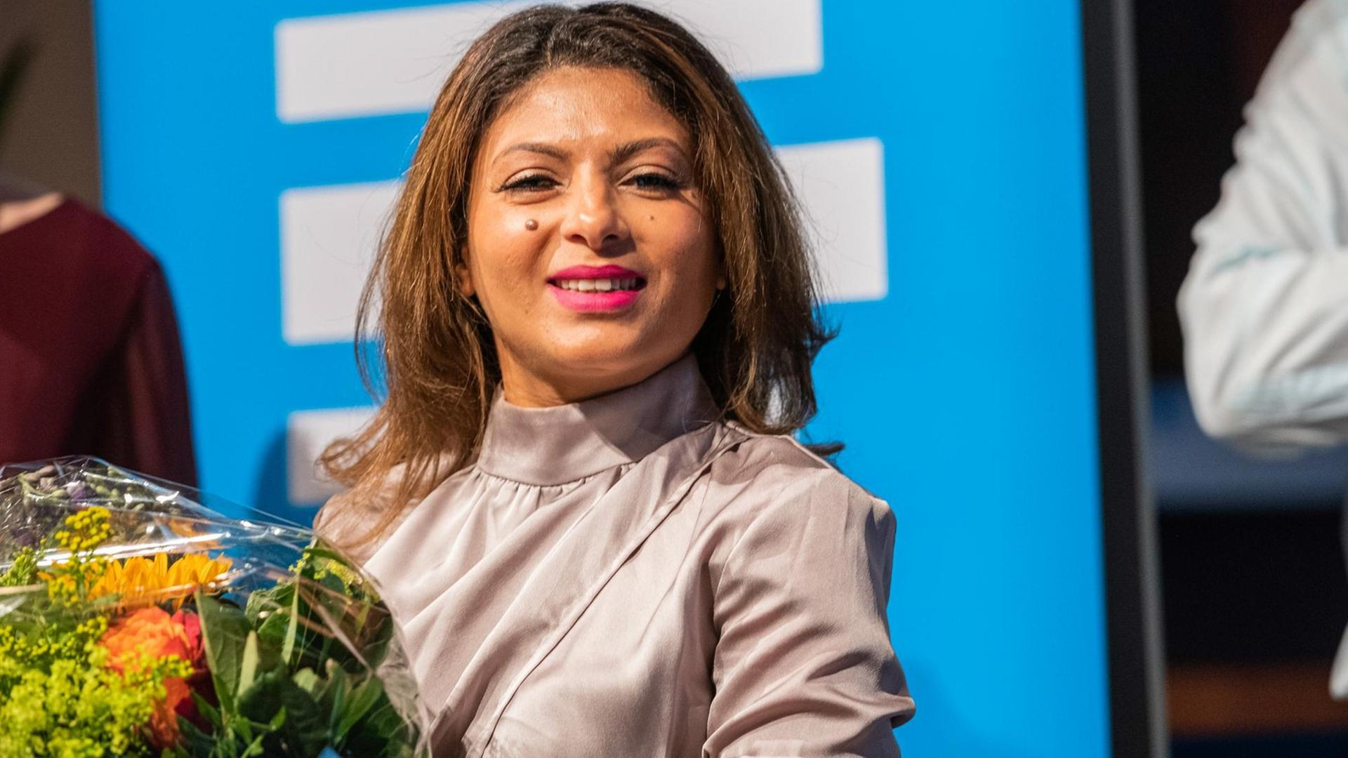 5. Kölner Forum für Journalismuskritik: Die Ehefrau des Bloggers Badawi mit Blumen. Sie lacht in die Kamera. 5. Kölner Forum für Journalismuskritik: Die Ehefrau des Bloggers Badawi mit Blumen. Sie lacht in die Kamera.