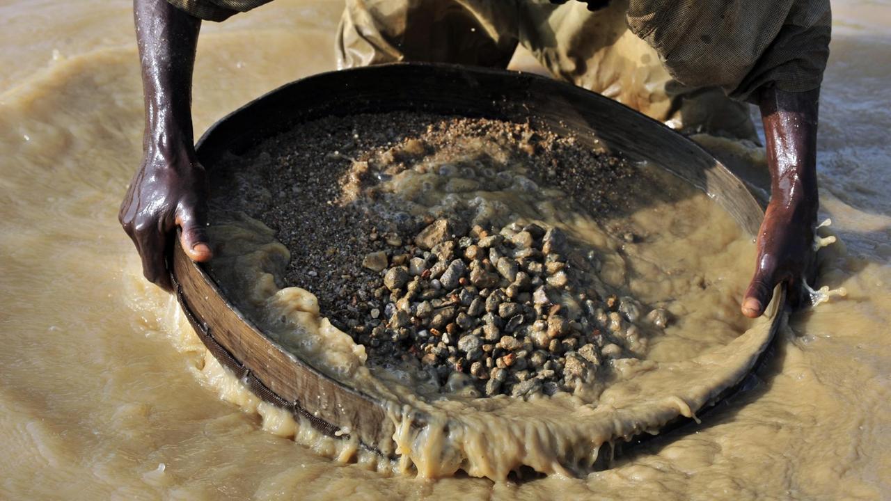 Ein Diamantensucher filtert in Koidu, der Hauptstadt des diamantenreichen Kono-Distrikts, im Osten Sierra Leones, Erde aus einem Fluss. Ein Diamantensucher filtert in Koidu, der Hauptstadt des diamantenreichen Kono-Distrikts, im Osten Sierra Leones, Erde aus einem Fluss.