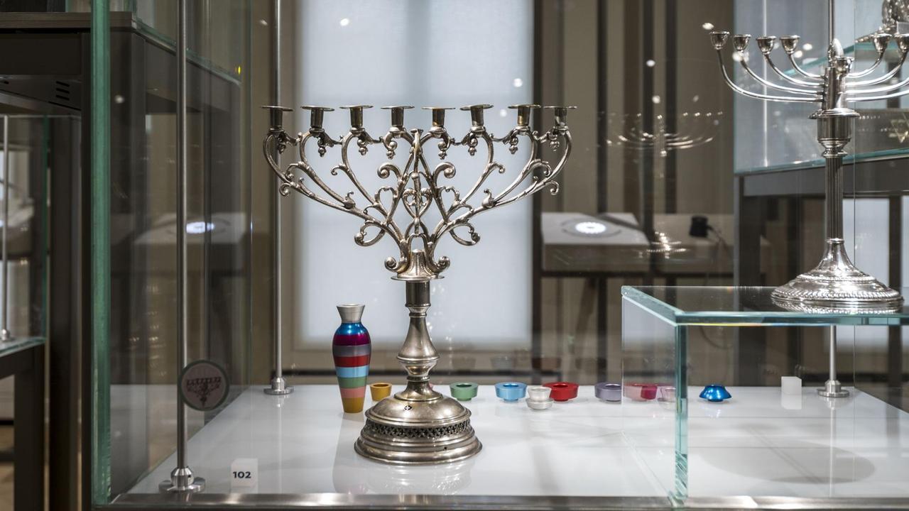 Zwei Chanukka-Kerzenhalter in einer Glasvitrine. Zwei Chanukka-Kerzenhalter in einer Glasvitrine.