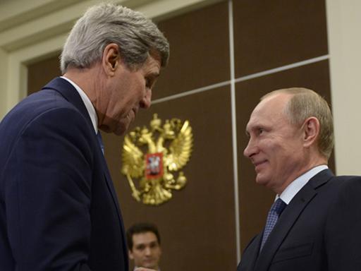 John Kerry und Wladimir Putin schütteln sich die Hände und lächeln sich an.