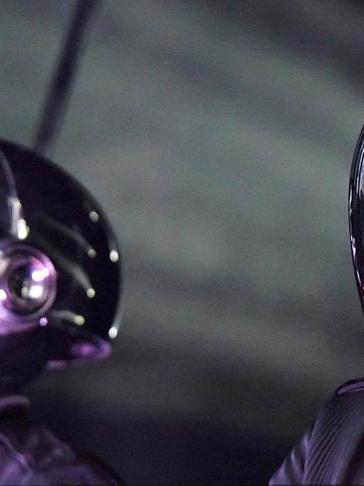 Die französische Band Daft Punk mit futuristischen Helmen während eines Auftritts.
